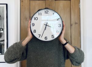 Anna Chapman holding a clock over her face - making time and space for yourself - Rhizo Home